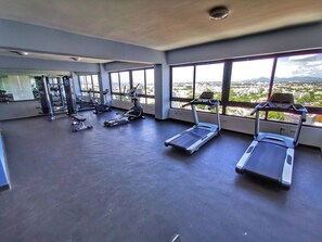 A gym with treadmills, elliptical machines, and weight equipment.