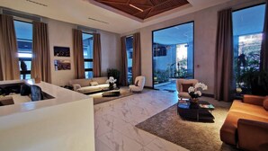 A spacious living area with a modern design, featuring a large sofa, a coffee table, and a dining area. - Goistay Discover Unparalleled Elegance in the Clouds A Luxury Apartment in th (Santo Domingo)