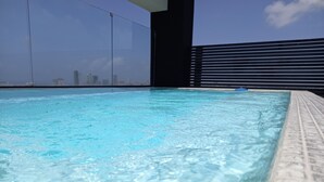 A clear blue pool with a city skyline in the background. - Goistay Discover Unparalleled Elegance in the Clouds A Luxury Apartment in th (Santo Domingo)