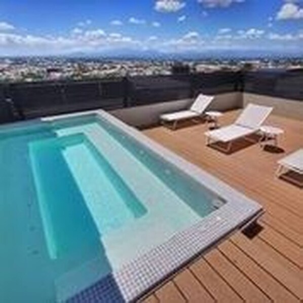 A rooftop pool area with a clear view of the city skyline.