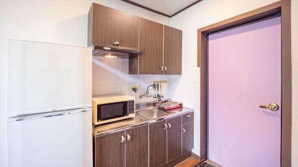 A compact kitchen with a microwave, toaster, and sink.