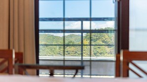 A room with a large window offering a view of a forested hillside and a bridge. - Gangchon Beautiful pet House Pension (Chuncheon)