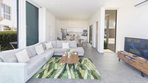 Ein modernes Wohnzimmer mit einer Couch, einem Couchtisch und einem Fernseher.