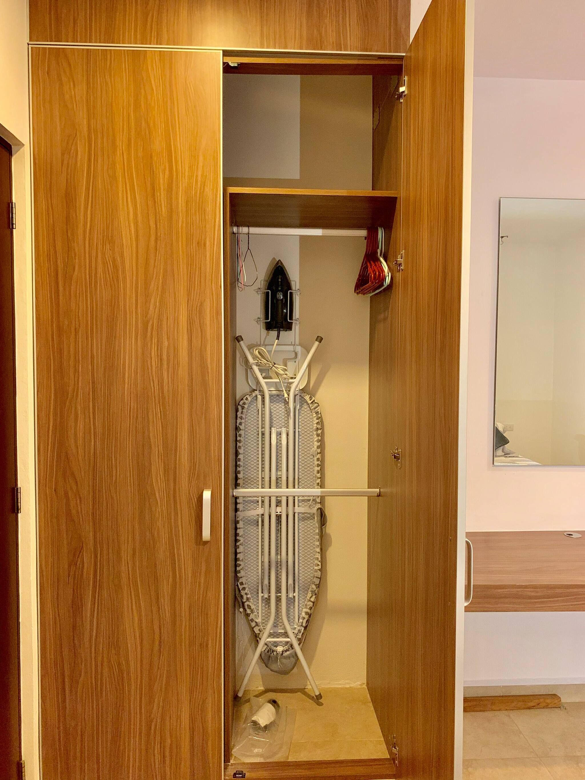 A wooden wardrobe with a hanging rack inside.