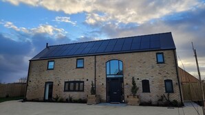 A two-story brick building with a flat roof and solar panels. - Lindum Barn, Ashlin Farm Barns (Lincoln)