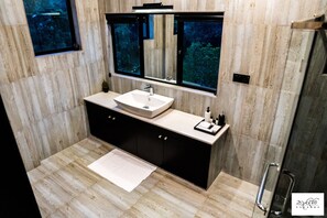 Une salle de bain moderne avec un grand miroir, un lavabo et une douche.