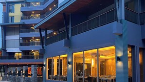 A multi-story hotel with balconies, large windows, and a modern architectural design. - The Proud Exclusive Hotel (Nakhon Pathom)