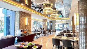 A modern dining area with high ceilings, reflective surfaces, and contemporary lighting fixtures. - The Proud Exclusive Hotel (Nakhon Pathom)