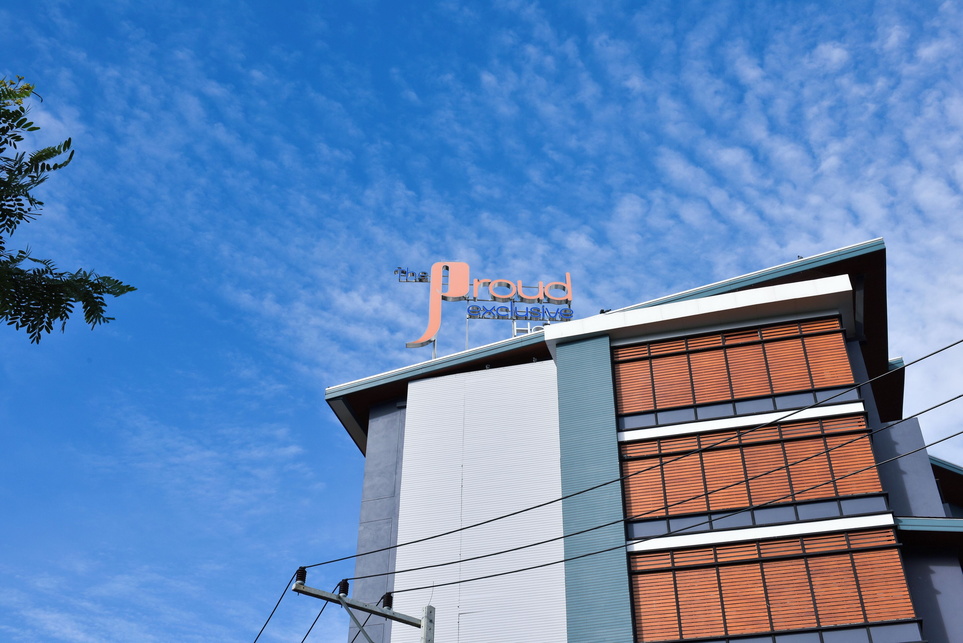 Un hotel con un letrero llamativo que dice 'The Proud Exclusive'.