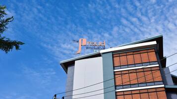 Un hotel con un letrero llamativo que dice 'The Proud Exclusive'.