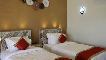 Une chambre d’hôtel avec deux lits, des têtes de lit en marbre, un élément décoratif mural et un tapis à motifs.