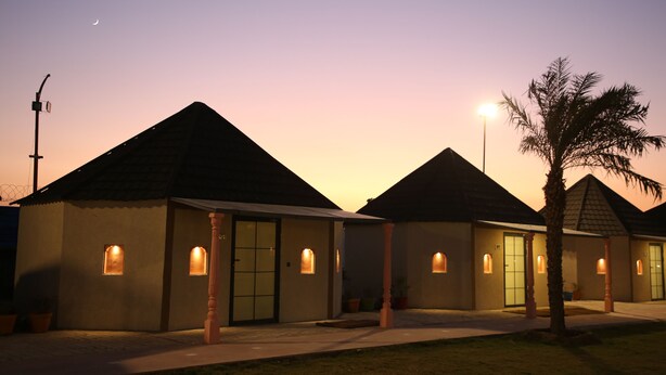 A row of small, single-story buildings with a consistent architectural style, featuring a central entrance and small windows. - Club 21by Sariska Fun city (Malakhera)