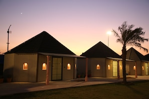 A row of small, single-story buildings with a consistent architectural style, featuring a central entrance and small windows. - Club 21by Sariska Fun city (Malakhera)
