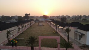 A courtyard with a central archway, surrounded by buildings with flat roofs and small windows. - Club 21by Sariska Fun city (Malakhera)