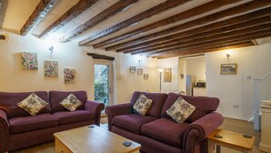A living room with two purple sofas, a wooden coffee table, and a wooden side table. - Duddon View  -  Duddon Valley, Lake District (Dog-friendly) (Seathwaite)