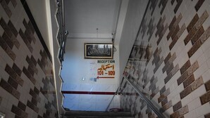 A reception area with a tiled wall and a sign indicating the reception desk is between 101 and 109. - Marwa Hotel and Restaurant (Abbottabad)