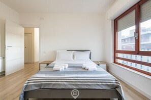 Quarto com uma cama, uma janela e uma porta.