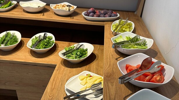 A wooden dining table with various dishes and utensils. - Park Otel (Düzce)