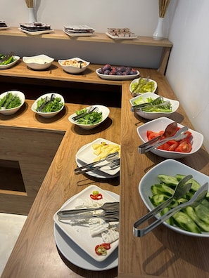 Una mesa de madera con varios platos y cubiertos.