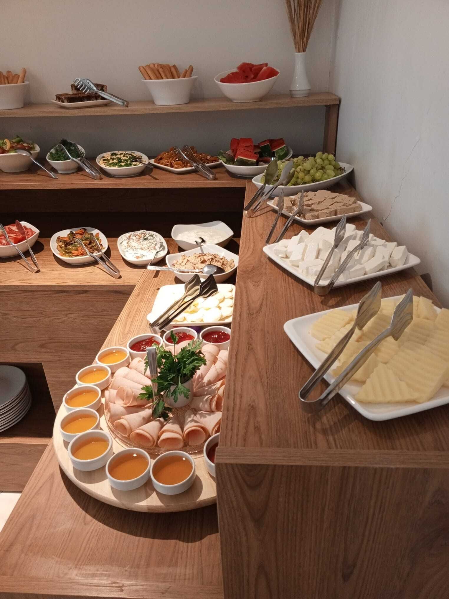 A buffet table with various food items including fruits, cheeses, and dips.