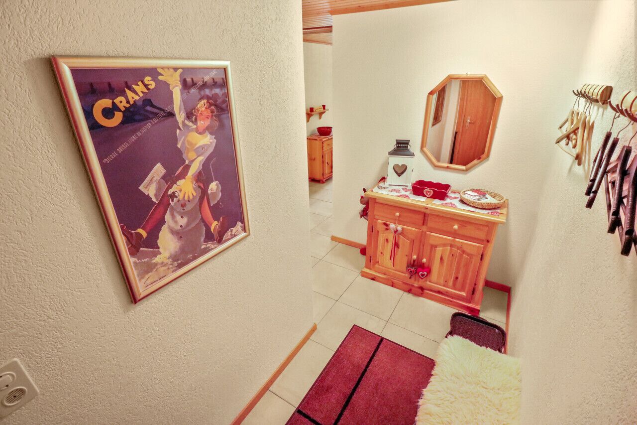 Een kamer met een houten kast, een spiegel en een lijst met een afbeelding aan de muur.