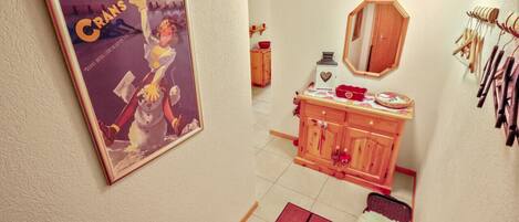 Una habitación con un armario de madera, un espejo y un cuadro en la pared.