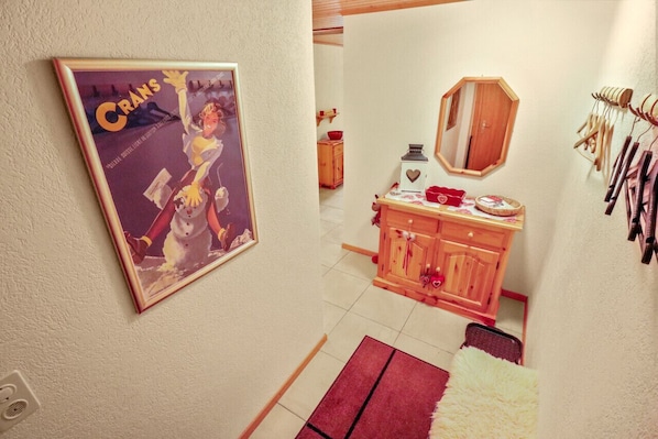 Una habitación con un armario de madera, un espejo y un cuadro en la pared.