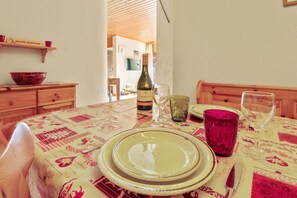 A dining table set with plates, a wine bottle, and glasses. - Superb apartment with free covered parking (Lens)