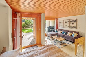 A cozy room with a wooden ceiling, a sofa, a coffee table, and a bed. - Excellent apartment with free covered parking (Lens)