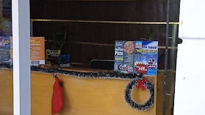 Un espace d’accueil avec un comptoir en bois, une horloge et un sac rouge accroché au mur.