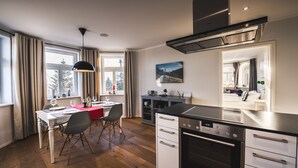 Ett modernt kök med matplats, trägolv och utsikt över omgivningen.