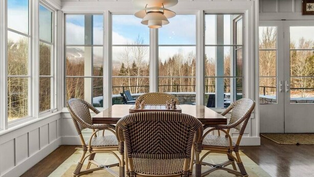 A dining area with a large table, wicker chairs, and a pendant light. - Private Mountain Estate | 7 Min to Okemo (Ludlow)