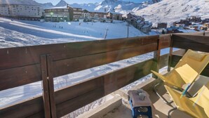 Un paysage de montagne enneigé, avec des bâtiments et une piste de ski.