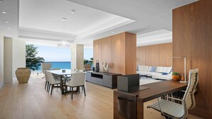 Un espacio de oficina moderno con un escritorio de madera, un sofá blanco y una zona de comedor.