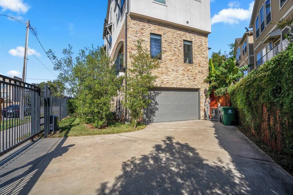 A modern building with a brick facade, a garage, and a gated entrance.