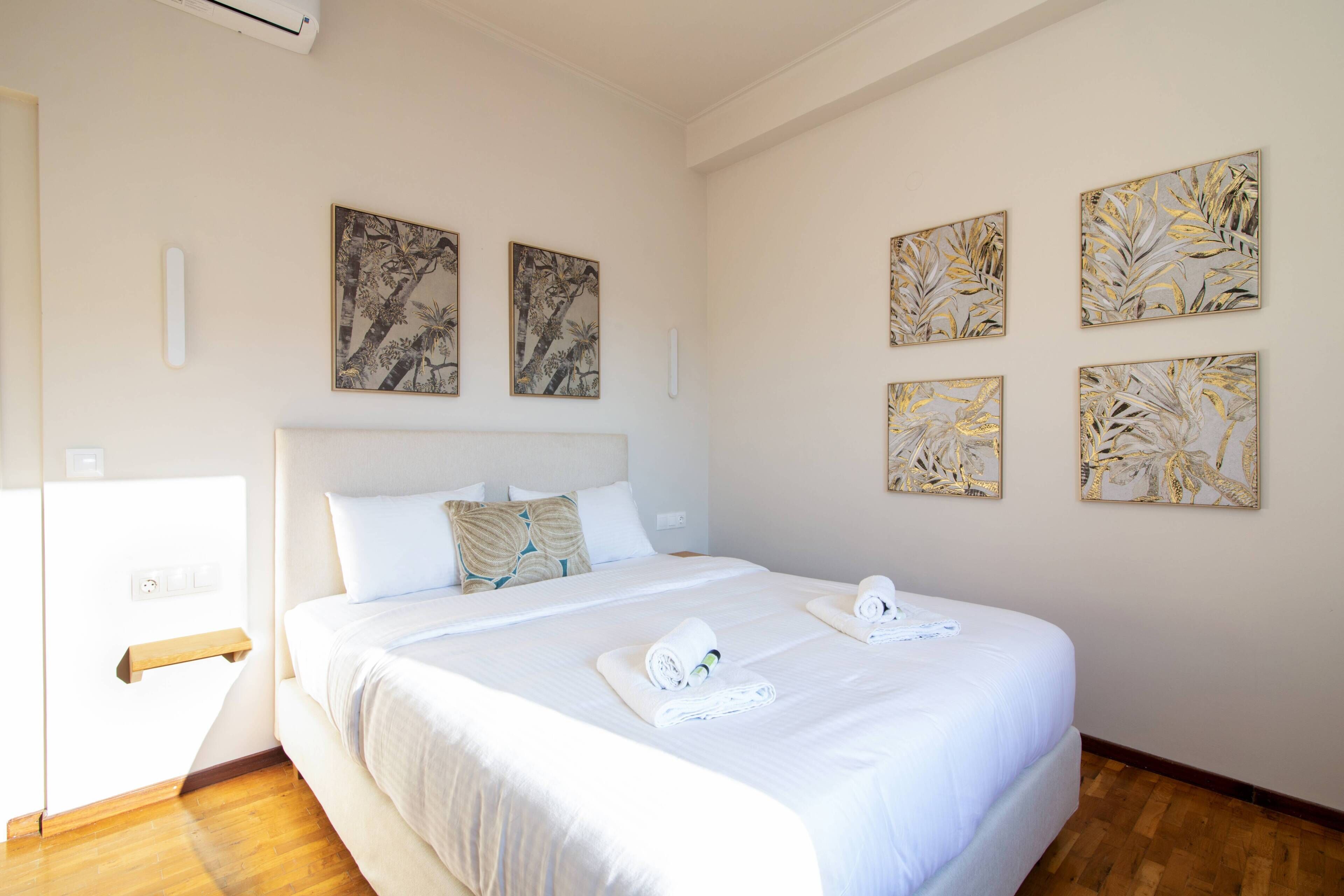 Una camera d'albergo con un letto grande, un comodino e un condizionatore d'aria a parete.