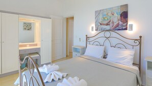 A bedroom with a bed, a nightstand, a painting, and a wardrobe. - Vista Mare Ilios in Nisaki (Corfu)