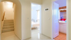 A hallway leading to a bedroom and a bathroom with a red basin. - Vista Mare Ilios in Nisaki (Corfu)