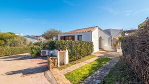 Una propiedad residencial con entrada pavimentada, un camino de piedra y un césped bien cuidado.