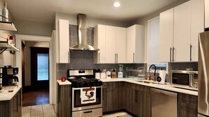 A modern kitchen with stainless steel appliances, a built-in oven, and a microwave. - Fischer House Indian Village Nn01 (Detroit)