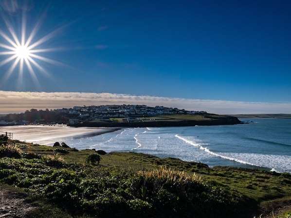 A coastal view with a beach, a village, and a clear sky.