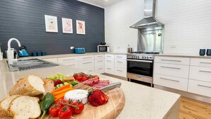 A modern kitchen with a wooden countertop, a built-in oven, and a stainless steel range hood. - Alfie's Place - A period classic in central location (NULKABA)
