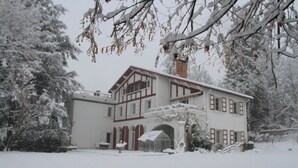 A large, two-story building with a symmetrical facade, a central entrance, and a covered porch area. - G1 Apartment with beautiful terrace between Grenoble and Chamrousse (Saint-Martin-d'Uriage)