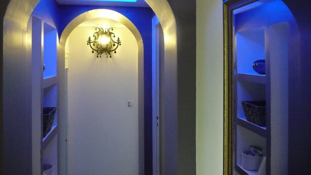 A hallway with an arched ceiling, a wall-mounted light fixture, and built-in shelving on the right side. - G1 Apartment with beautiful terrace between Grenoble and Chamrousse (Saint-Martin-d'Uriage)
