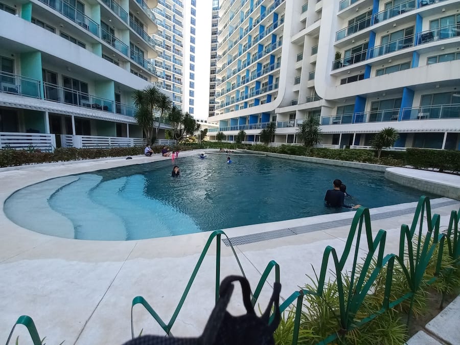 A swimming pool surrounded by high-rise residential buildings with balconies.