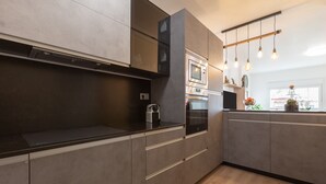A modern kitchen with built-in appliances, a wooden countertop, and a hanging light fixture. - Holiday Apartment "Palma De Mallorca 12" with Private Terrace, A/C & Wi-Fi (Torremolinos)