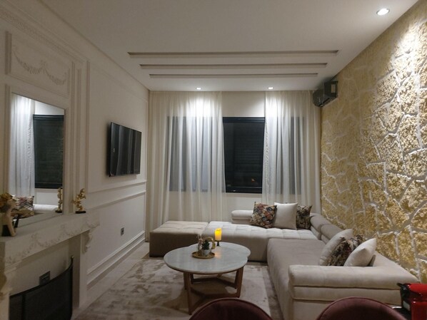 Una sala de estar moderna con un conjunto de sofá, una mesa de centro redonda y una chimenea.