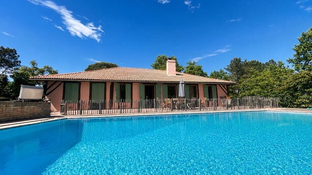 A swimming pool with a house in the background.