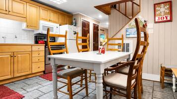 A kitchen with wooden cabinets, a white table, and chairs.