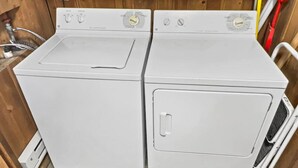 A compact, white laundry room with two stacked washers and dryers, wooden walls, and a tiled floor. - Townhome Near Slopes Village Gated Parking Wi-Fi (Snowshoe)